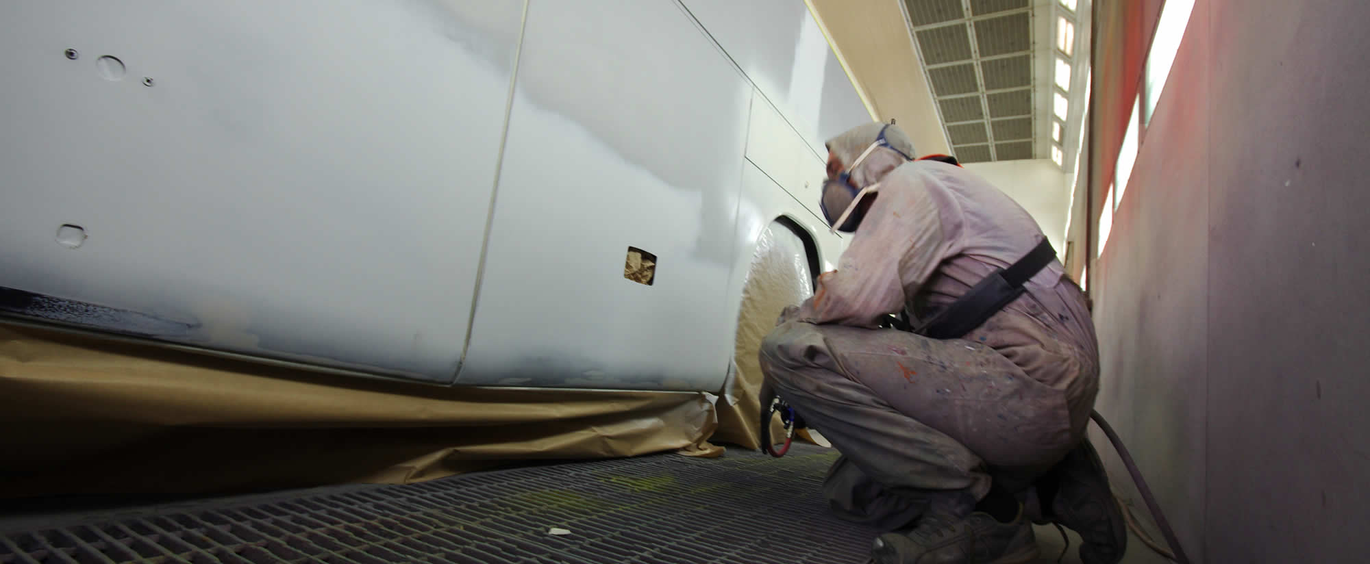 Painter spraying a coach panel in the ACT paint shop