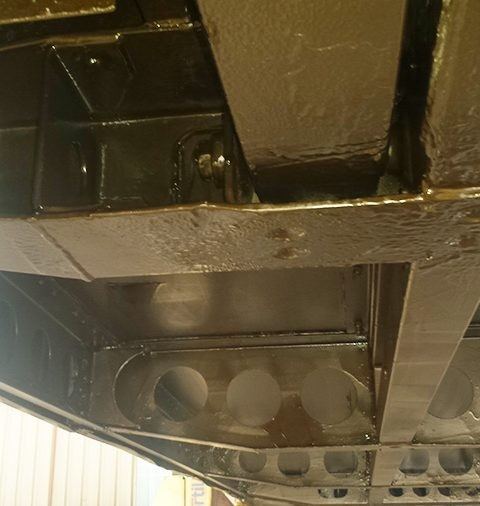Coach chassis underside after undersealing, with a fresh protective coating on the frame and cross-members