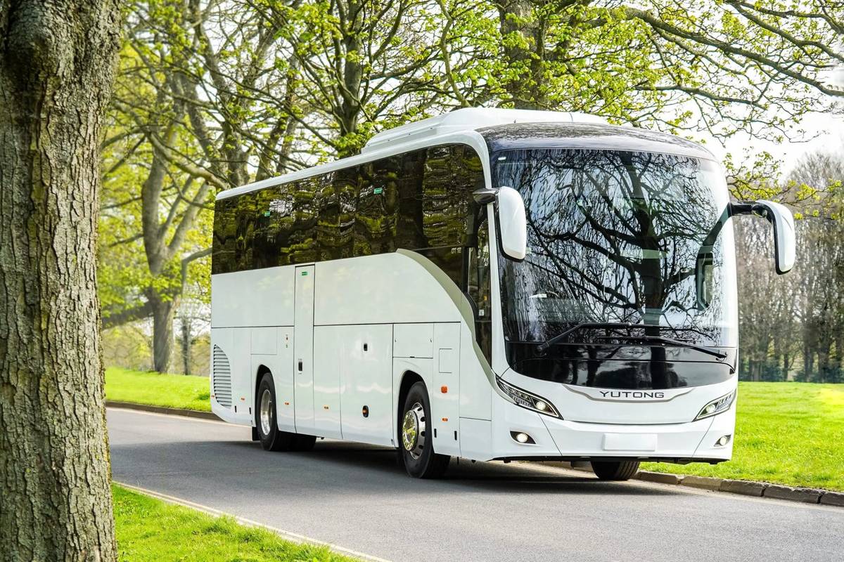 White Yutong GT12 coach on a tree-lined road